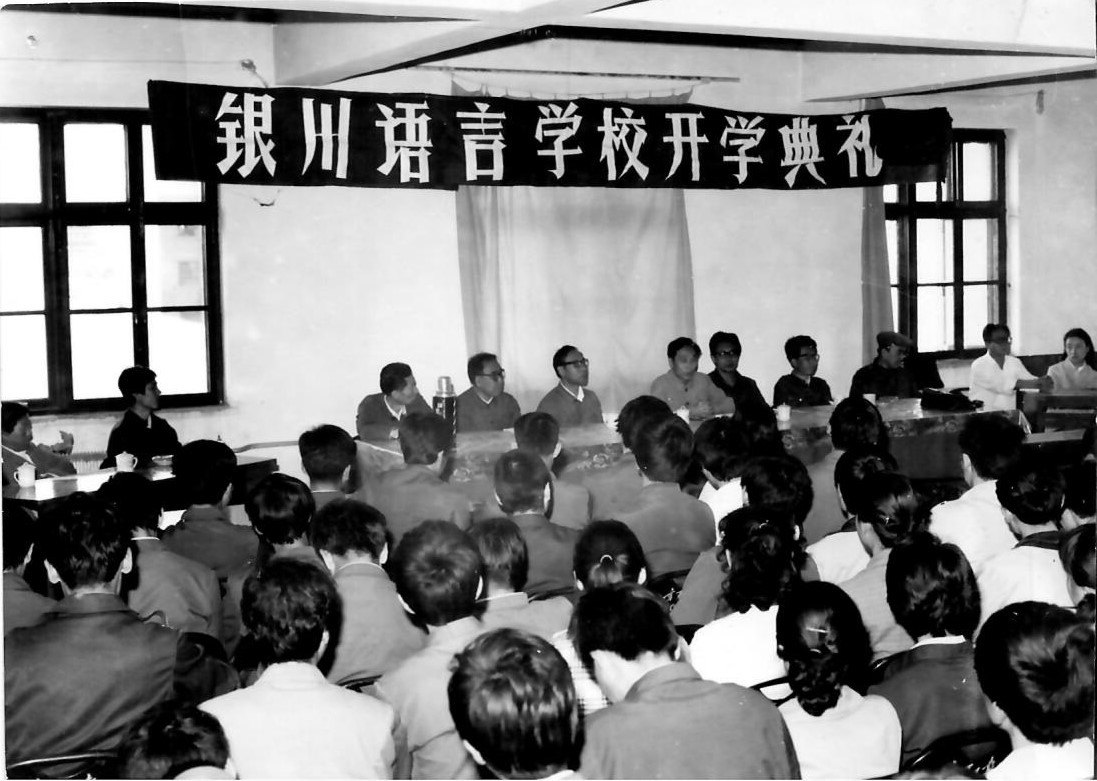 王明仁（1934年3月生），黑龙江省克山县人，宁夏大学中文系教授。1984年创办银川语言学校，开创并推进了宁夏阿拉伯语正规化教育。出版专著有《实用语法讲话》《语法学习和教学》《现代汉语语法》《咬文嚼字又一说》。图为1984年9月，银川语言学校开学典礼。